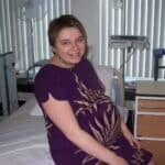 A woman demonstrating her plurality while sitting on a bed.